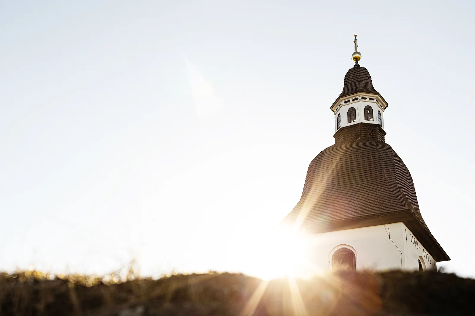 Kyrka i varmt motljus vid solnedgång